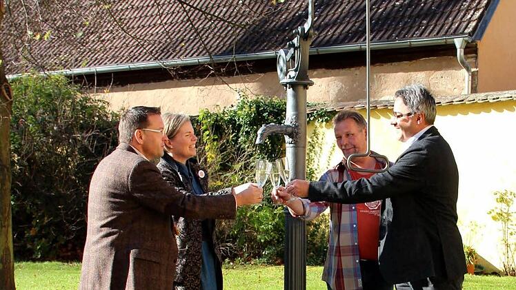 Vor dem frisch restaurierten Pumpbrunnen und auf weitere Spender stoßen an: Karsten Fischkal, Kerstin Blum, Siggi Kraus und Wolfgang Mößlein