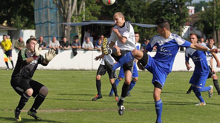 Der Burgkunstadter Spielertrainer Marco Dießenbacher (weiß) versucht eine scharfe Hereingabe abzuwehren die von Sertan Sener abgelenkt wird. Foto: Heinrich Weiß