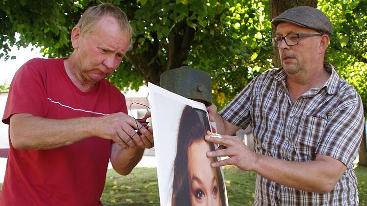 Gerd Kastner (l.) und Thilo Moosmann bringen immer häufiger die modernen Hohlkammer-Plakate an, wie hier eines von Doris Aschenbrenner. Das erleichtert ihre Arbeit deutlich. Foto: Marco Meißner
