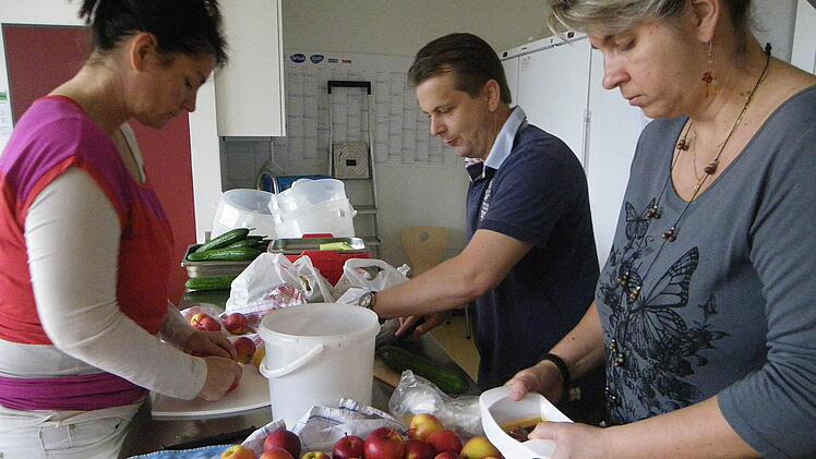 Petra Wiesner-Molitor, Wolfgang Weller und Anna Wichary schnippeln eifrig Äpfel, aber auch Gemüse. Foto: Regina Rinke
