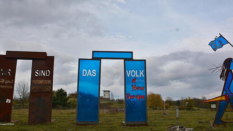 Die Skulptur "Wir sind das Volk" steht wieder am alten Platz. Im Hintergrund der Wachturm.