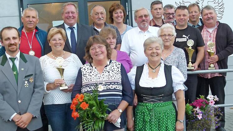 Hannelore Agly (vorne, mit Blumen) ist die neue Dorfkönigin. Weiter im Bild die Vertreter der siegreichen Vereine zusammen mit Bürgermeister Volker Schmiechen (Vierter von links), Erstem Schützenmeister Mark Trapper (links), stellvertretendem Vorsitzenden Hans Kaspar (Achter von rechts) und der Vorsitzenden der Schützengesellschaft, Inge Winkler (vorne, rechts) Foto: Werner Oetter