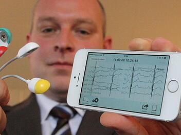 Sebastian Dresbach vom Zentrum für Telemedizin zeigt, wie Nutzer mit dem Handy ein EKG erstellen können. Foto: Ralf Ruppert