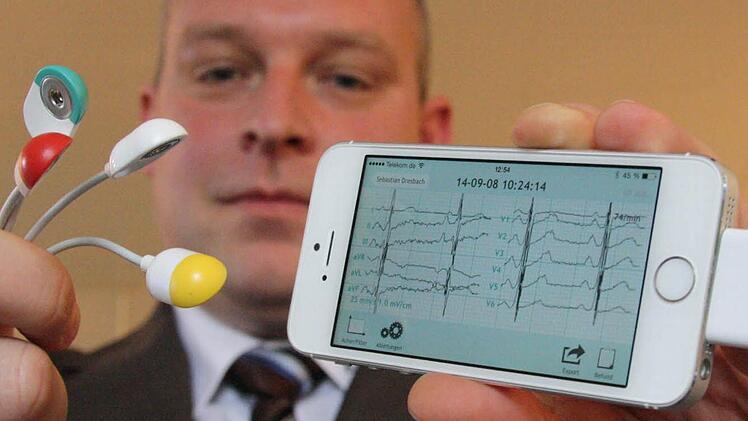 Sebastian Dresbach vom Zentrum für Telemedizin zeigt, wie Nutzer mit dem Handy ein EKG erstellen können. Foto: Ralf Ruppert