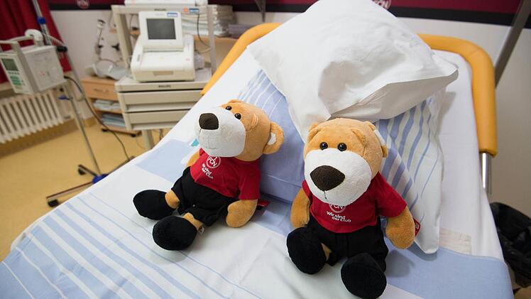 Zwei FCN-Teddybären liegen am 15.12.2015 in Nürnberg (Bayern) im FCN-Kreißsaal des Klinikums Nürnberg Süd. Foto: Timm Schamberger /dpa