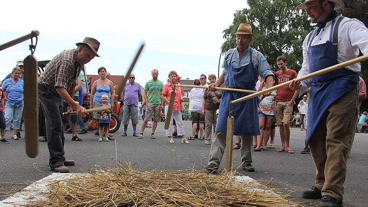 Dreschen der Getreideähren mit alten Dreschflegeln.