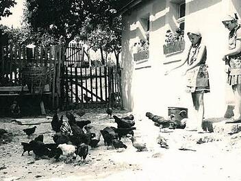 Die achtjährige Gertrud (Glössner-Möschk) mit ihrer Freundin (rechts) beim Füttern der Hühner, während sie mit den Gänsen ihrer Großeltern "auf Kriegsfuß" lebte.  Foto: Harry Glössner