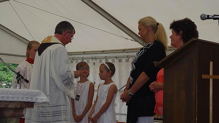 Auch die diesjährigen Kommunionkinder (von links) Leonie und Jana ließen sich von Karmelitenpater Roland Hinzer in die Skapulierbruderschaft aufnehmen. Foto: Heike Schülein