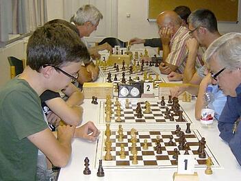Konzentriert und mit angestrengten Mienen sitzen die Mitglieder des Gräfenberger Schachclubs über ihren Schachbrettern  Foto: Petra Malbrich