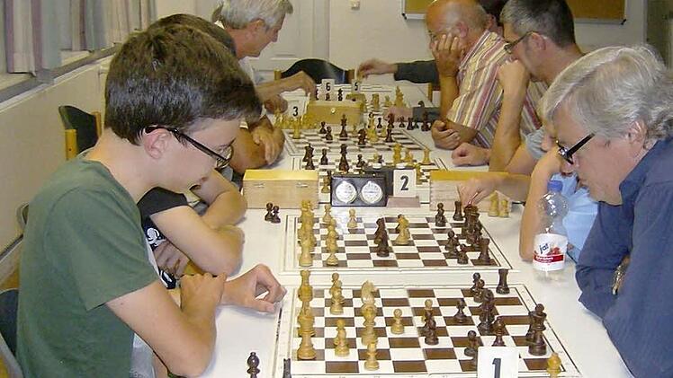 Konzentriert und mit angestrengten Mienen sitzen die Mitglieder des Gräfenberger Schachclubs über ihren Schachbrettern  Foto: Petra Malbrich