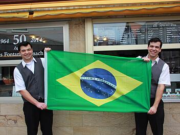 Die beiden Brüder Adriano und Dione Pedroso (von links) halten stolz die Flagge ihres Heimatlandes Brasilien hoch. Foto: Davina Zipfel