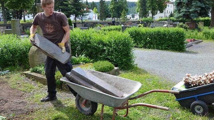 Die Katholische Jugend Kronach kümmerte sich um die verwaisten Gräber auf dem Friedhof. Hier ist Benjamin Wipfler bei der Arbeit.