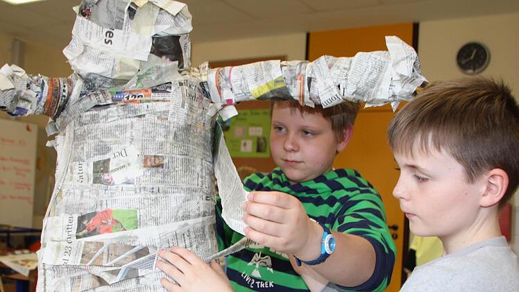 Conor und Nino wickeln den Affen-Krebs wie eine Mumie ein.
