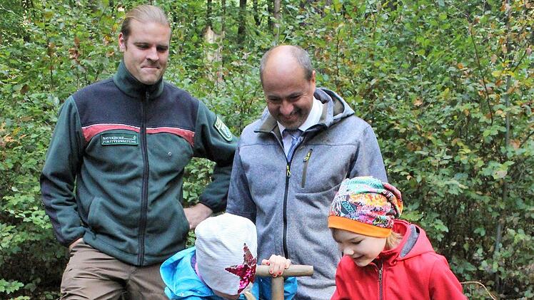 Auch Bürgermeister Johannes Krapp (rechts) bekam eine Edelkastanie. Auf einem Holzschild mit seinem Namen wird ihm der Baum zugeschrieben. Förster Benjamin Göbel (links) schaut, dass die Schüler alles richtig machen.    Foto: Evi Seeger
