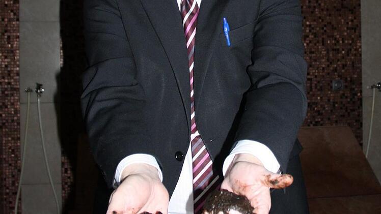 Stadtwerke-Chef Manfred Zimmer zeigt das Moor, mit dem sich die Besucher einreiben können.