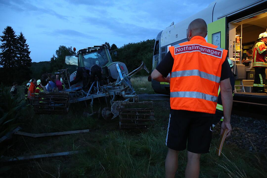 Traktor kracht in Zug - Glücklicherweise lediglich Zuginsassin und Traktorfahrer verletzt – Kollision erfolgte an unbeschranktem Bahnübergang – Unfallursache noch unklar – Großaufgebot an Rettungskräften alarmiert