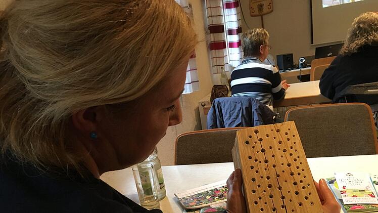 Eine Besucherin nimmt eine Nisthilfe unter die Lupe. Kerstin Väth