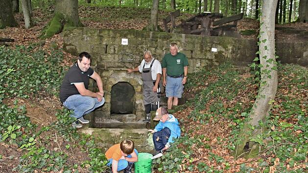 Am "Hasenbr&uuml;nnle", zwischen B&uuml;hl und Jesserndorf gelegten, freuen sich mit den Kindern im Vordergrund (hinten von links), Christian Schmitt, Vorsitzender des HBV Jesserndorf, Hans Kern und Heinz Fausten, &uuml;ber die gelungene Ausbesserung der Quelle des "Hasenbr&uuml;nnle." Foto: Helmut Will