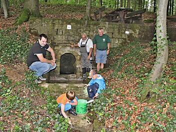 Am "Hasenbrünnle", zwischen Bühl und Jesserndorf gelegten, freuen sich mit den Kindern im Vordergrund (hinten von links), Christian Schmitt, Vorsitzender des HBV Jesserndorf, Hans Kern und Heinz Fausten, über die gelungene Ausbesserung der Quelle des "Hasenbrünnle." Foto: Helmut Will