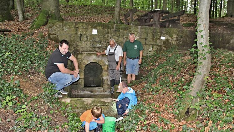 Am "Hasenbrünnle", zwischen Bühl und Jesserndorf gelegten, freuen sich mit den Kindern im Vordergrund (hinten von links), Christian Schmitt, Vorsitzender des HBV Jesserndorf, Hans Kern und Heinz Fausten, über die gelungene Ausbesserung der Quelle des "Hasenbrünnle." Foto: Helmut Will