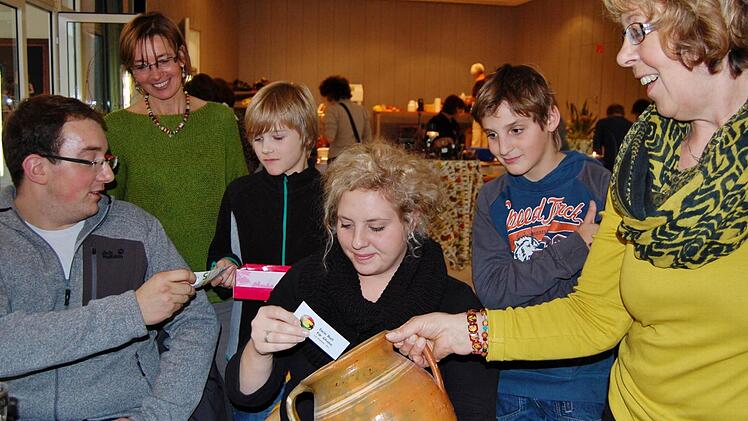 Sigrid Klemke (rechts) und Karin Gabel (hinten links) verkaufen Lose für den guten Zweck. Foto: Sigismund von Dobschütz