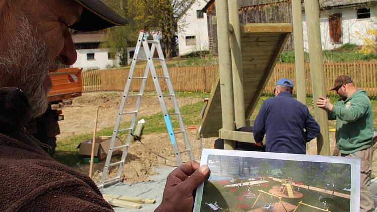 Vorarbeiter Heinz Popp und seine Kollegen Alexander Kober und Klaus Pfändner (im Hintergrund, von rechts) vom Bauhof stellen die Geräte auf dem neuen Spielplatz in Gumpersdorf auf. Foto: Matthias Beetz