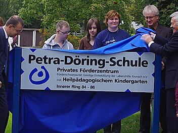 Christian Behner (links neben dem Schild) und Manfred Döring (rechts neben dem Schild) enthüllten im Beisein vieler Gäste das neue Namensschild der Schule.  Foto: Heike Schülein