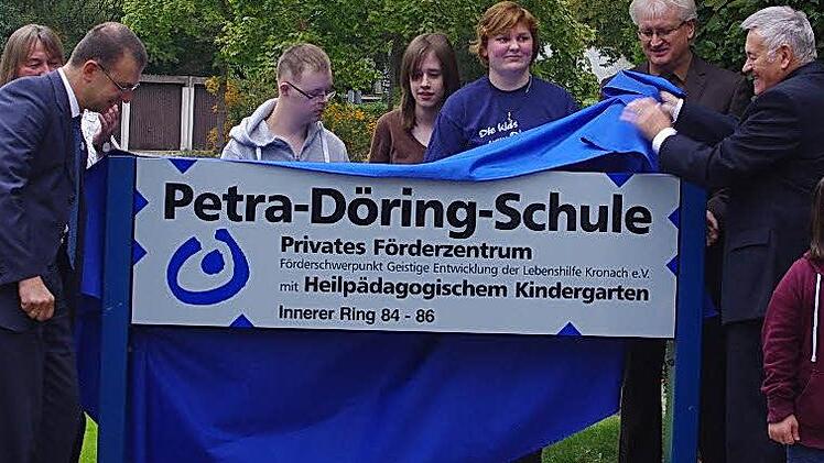 Christian Behner (links neben dem Schild) und Manfred Döring (rechts neben dem Schild) enthüllten im Beisein vieler Gäste das neue Namensschild der Schule.  Foto: Heike Schülein