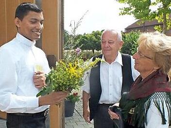 Caecilia Paulus &uuml;berreicht dem sichtlich erfreuten Thomas Shine einen Wurzb&uuml;schel. Foto: Manfred Welker