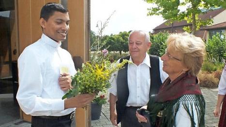 Caecilia Paulus &uuml;berreicht dem sichtlich erfreuten Thomas Shine einen Wurzb&uuml;schel. Foto: Manfred Welker