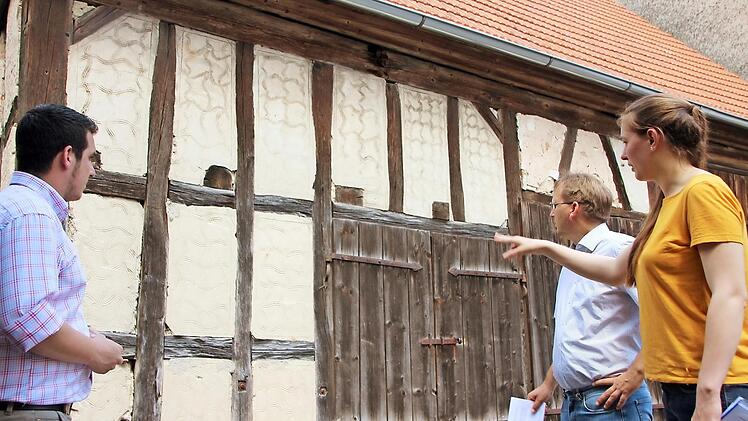 Laura Deglmann zeigt den Bürgermeistern Maximilian Neeb (links) und Wolfram Thein Besonderheiten an der Fassade des alten Brauhauses von Eckartshausen.  Fotos: Eckehard Kiesewetter