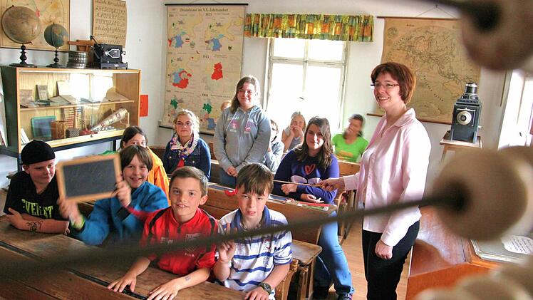 Den Rechenschieber vor Augen: Die Kinder, die sich derzeit zu Museumsführern ausbilden lassen, erleben bei einer Mathestunde im historischen Schulzimmer, wie streng es früher im Unterricht zuging. Gut, dass Museumspädagogin Annemarie Heuler den Rohrstock nur zu Anschauungszwecken einsetzt. Foto: Michael Will