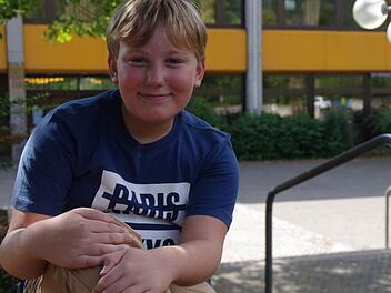 Keine Angst vor der neuen Schule: Der zehnjährige Alexander Ivascenko freut sich schon auf den Start am Frankenwald-Gymnasium (im Hintergrund) am heutigen Dienstag. Foto: Marco Meißner
