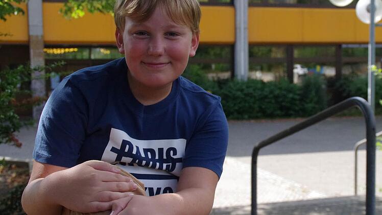 Keine Angst vor der neuen Schule: Der zehnjährige Alexander Ivascenko freut sich schon auf den Start am Frankenwald-Gymnasium (im Hintergrund) am heutigen Dienstag. Foto: Marco Meißner