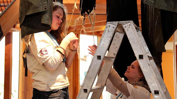 Jule (l.) und Kim hängen die nassen Planen auf. Foto: Johanna Blum