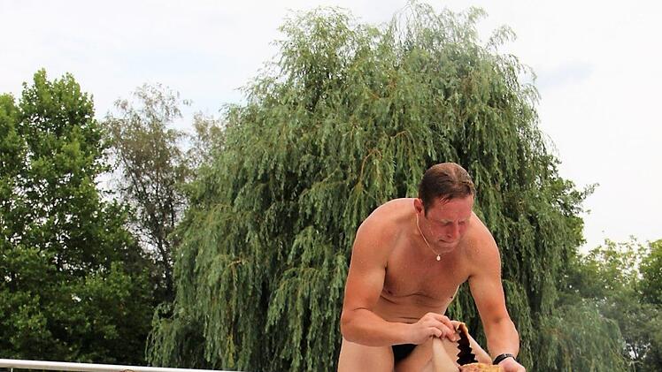 Chris Riel (links) schmiert Füße und Beine mit Öl ein, damit die Flosse besser "flutscht". Bäder-Betriebsleiter Peter Zimmermann muss erst einmal herausfinden, wie man die Flosse am besten nach außen stülpt.Diana Fuchs