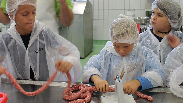 Teamwork: Abdrehen der Bratwürste und Auseinanderschneiden in einem Aufwasch.