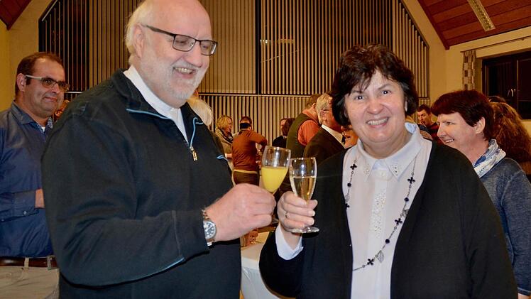 Dekan Stephan Hartmann und Margot Markart, die Vorsitzende der Pfarreienkonferenz, stoßen beim Neujahrsempfang der Pfarreiengemeinschaft auf ein erfolgreiches neues Jahr an.. Foto: Kathrin Kupka-Hahn