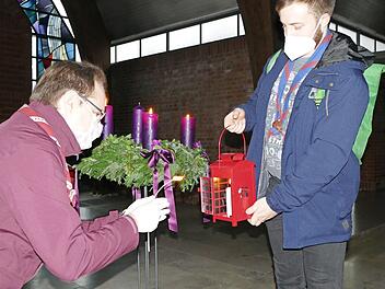 Landeskurat Tobias Bienert (links) übergibt das Friedenslicht aus Bethlehem an Rover Finn Kolmstädter, der es in andere Bamberger Kirchen weiterträgt.  Foto: Marion Krüger-Hundrup