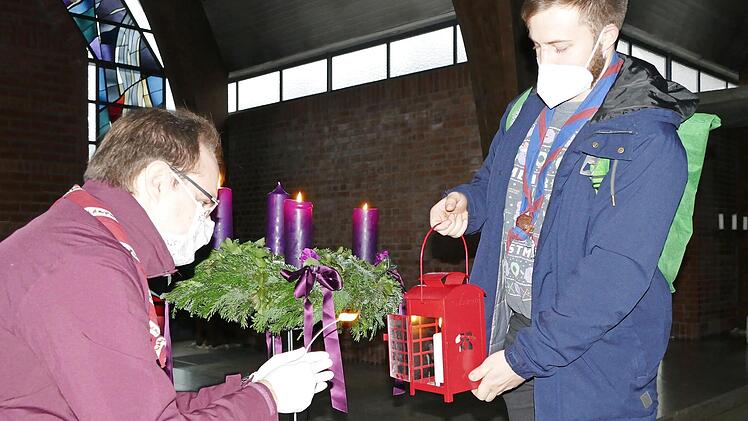 Landeskurat Tobias Bienert (links) übergibt das Friedenslicht aus Bethlehem an Rover Finn Kolmstädter, der es in andere Bamberger Kirchen weiterträgt.  Foto: Marion Krüger-Hundrup