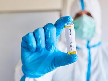 Forscher in Schutzkleidung testen den Corona-Wirkstoff.