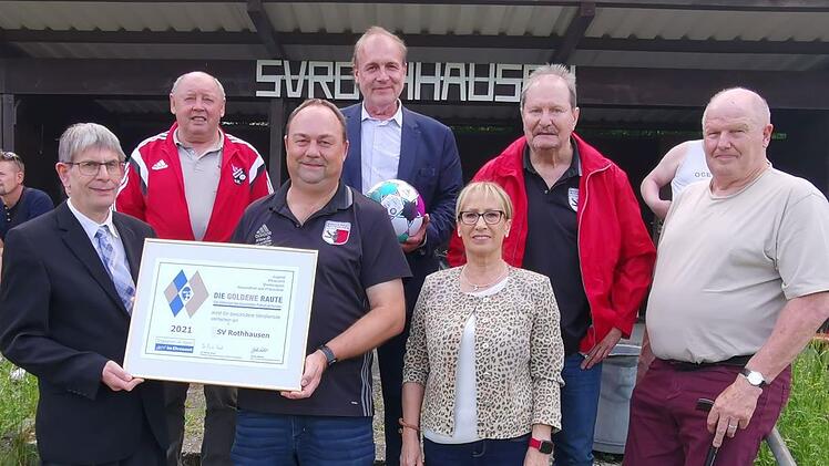 Das Foto zeigt bei der Übergabe der Goldenen Raute hinten (von links) die beiden Vereinsehrenamtsbeauftragten Hilmar Kehl und Daniel Wiener sowie Ehrenvorsitzenden Roland Beck. Vorne sind zu sehen (von links): Kreisehrenamtsbeauftragter Klaus Eisenmann, Vorsitzenden Bernd Müller, Bürgermeisterin Judith Dekant und BFV-Kreisvorsitzenden Rainer Lochmüller.