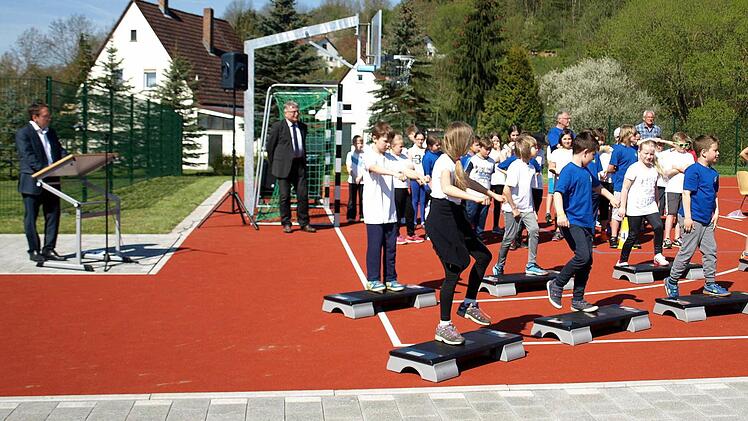 Die Schüler der 3b zeigen bei der Einweihung der Außensportanlagen Step-Aerobic. Links Bürgermeister Norbert Gräbner und Schulamtsdirektor Uwe Dörfer. Foto: Susanne Deuerling