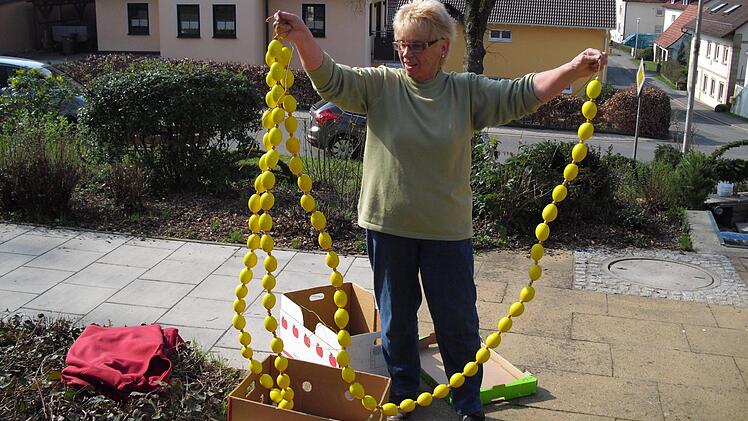 Zum Schluss wird der Osterbrunnen geschmückt. Foto: Helmut Klösel