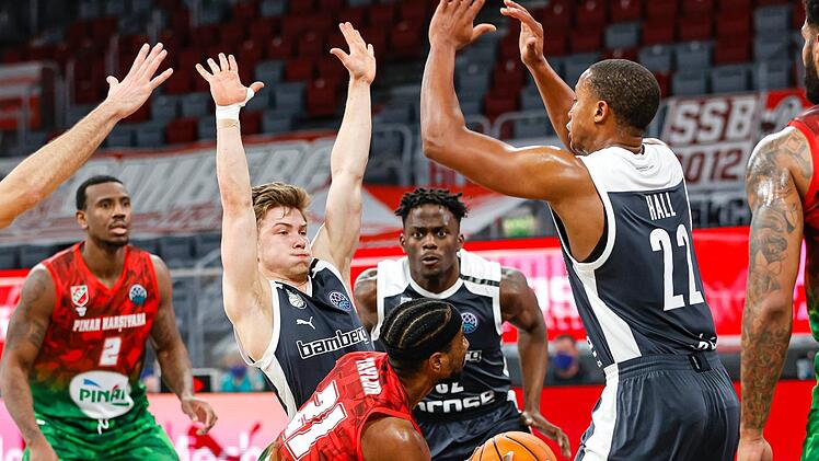 Gute Team-Defense zeigen hier die Bamberger (von links) Bennet Hundt, Norense Odiase und Devon Hall gegen Tony Taylor. Foto: Daniel Löb