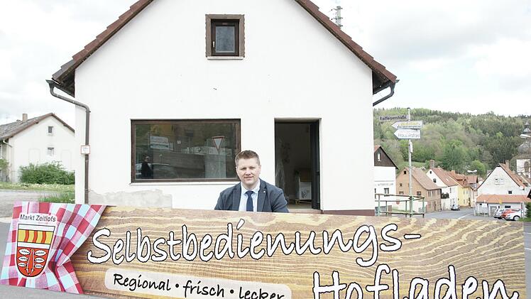 Hoffnungsvoll präsentierte Bürgermeister Matthias Hauke im Mai 2021 das Schild für den Zeitlofser Dorfladen, der im Juli desselben Jahres  öffnete. Ende Oktober schließt er Stand jetzt wieder. Foto: Archiv/Steffen standke