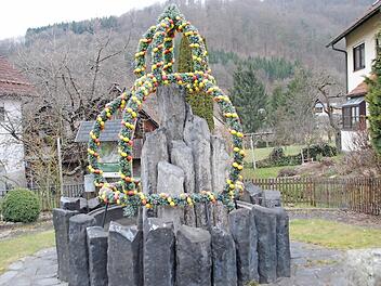 Auch für das diesjährige Osterfest ist der Basaltbrunnen in der Sinntalstraße vom Obst- und Gartenbauverein mit einer Osterkrone versehen worden.  Foto: Evelyn Schneider