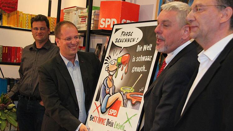 Ein Werner-Plakat für den Werner-Fan Norbert Tessmer, überreicht von SPD-Geschäftsführer Oliver Jauernig (links) und Stadtratsfraktiosnvorsitzendem Thomas Nowak (rechts).