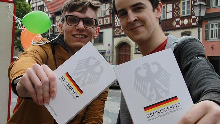 Julian Wenzel (links) und Jakob Schlilizio sind zwei der sieben Bufdis, die mit den Passanten auf dem Staffelsteiner Marktplatz den 64. Geburtstag des Grundgesetzes feierten. Fotos: Matthias Einwag