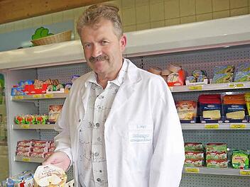 Milchwerke-Direktor Ludwig Weiß und sein persönlicher Lieblingskäse aus dem Kühlregal im Wiesenfelder Milchwerke-Laden: der 350 Gramm schwere "Bayerische Landkäse". Foto: Berthold Köhler